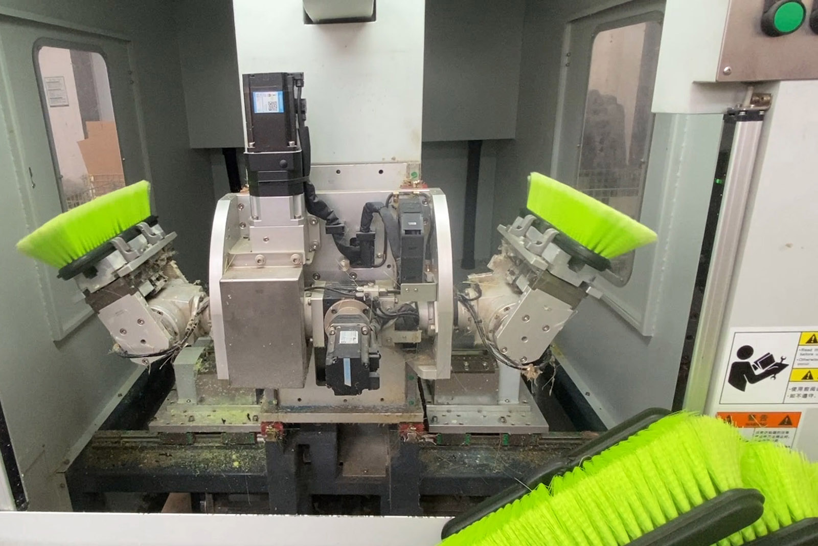 CNC bristle trimming machine with green brushes and dual robotic arms